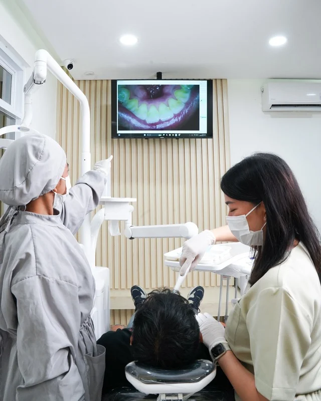 Dokter gigi sedang melayani pasien